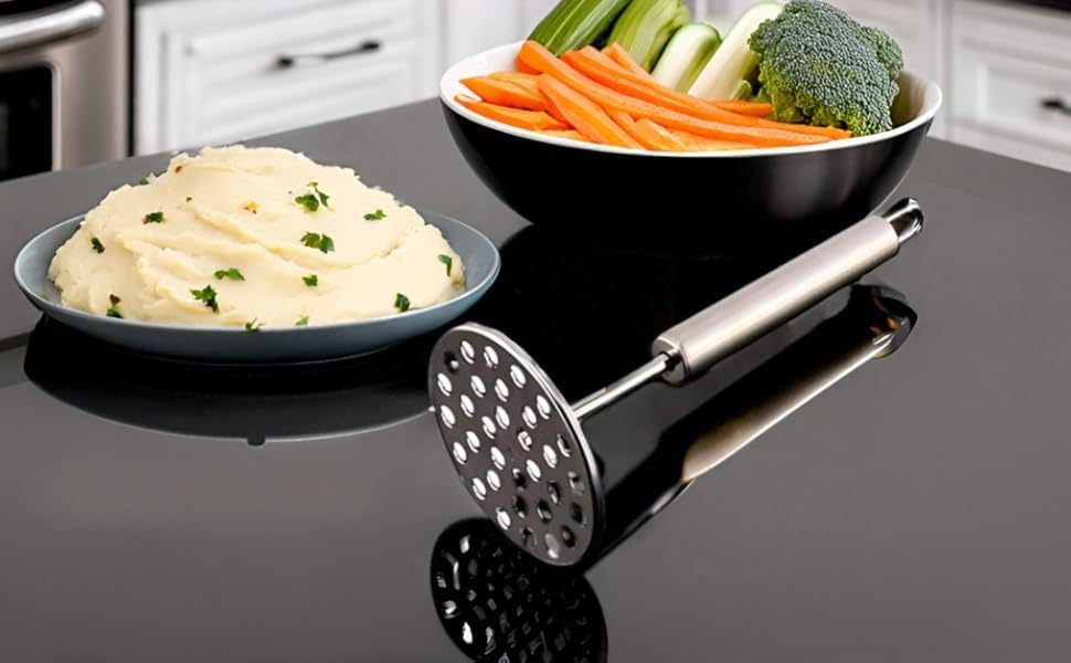 Stainless steel masher beside mashed potato and vegetables