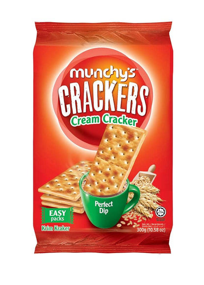 An open pack of Munchy's Wheat Crackers, with a hand reaching for a cracker, ready for snacking.