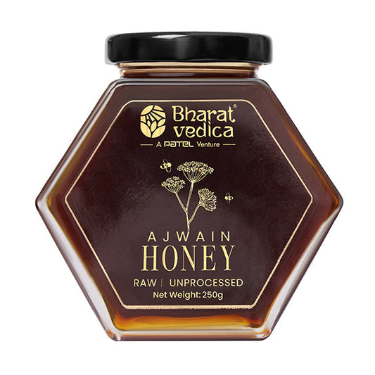 Bharat Vedica Ajwain Flower Honey in a hexagon bottle, showcasing its rich amber color.