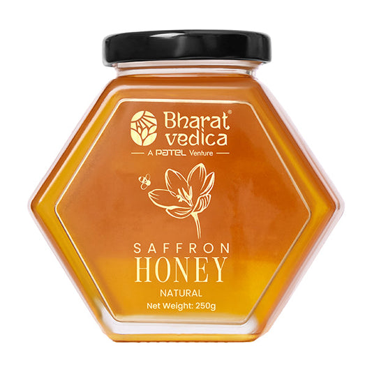 Bharat Vedica Saffron Honey in a signature hexagon bottle, showcasing its rich golden color with saffron strands.