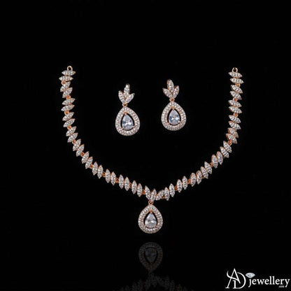Matching earrings showcasing pear-shaped centerpieces and leafy motifs