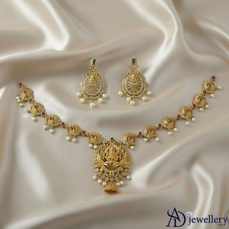 Earrings detail with faux green gem and pearl drops.
