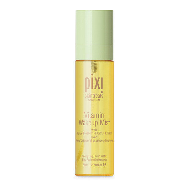 A hand holding the Pixi Beauty Vitamin Wakeup Mist, ready to apply the revitalizing spray to skin.